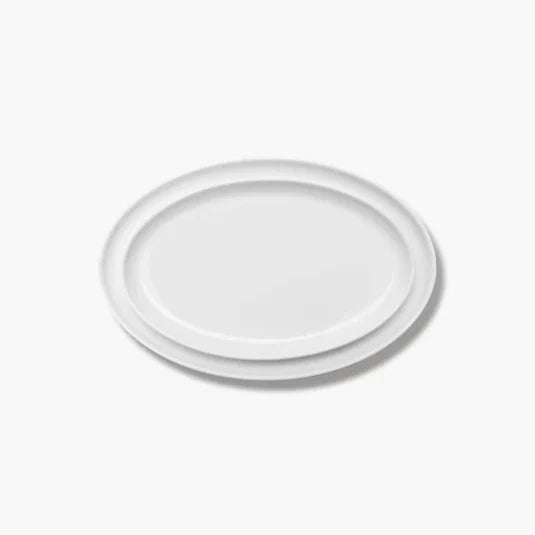 Een set van twee Serax Passe-Partout ovale borden in wit mat, elegant gepresenteerd op een horeca-tafelsetting.